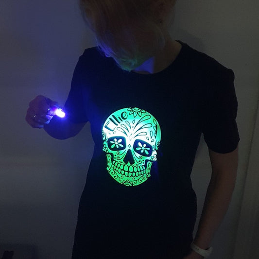 Woman shining a torch on glow in the dark t-shirt